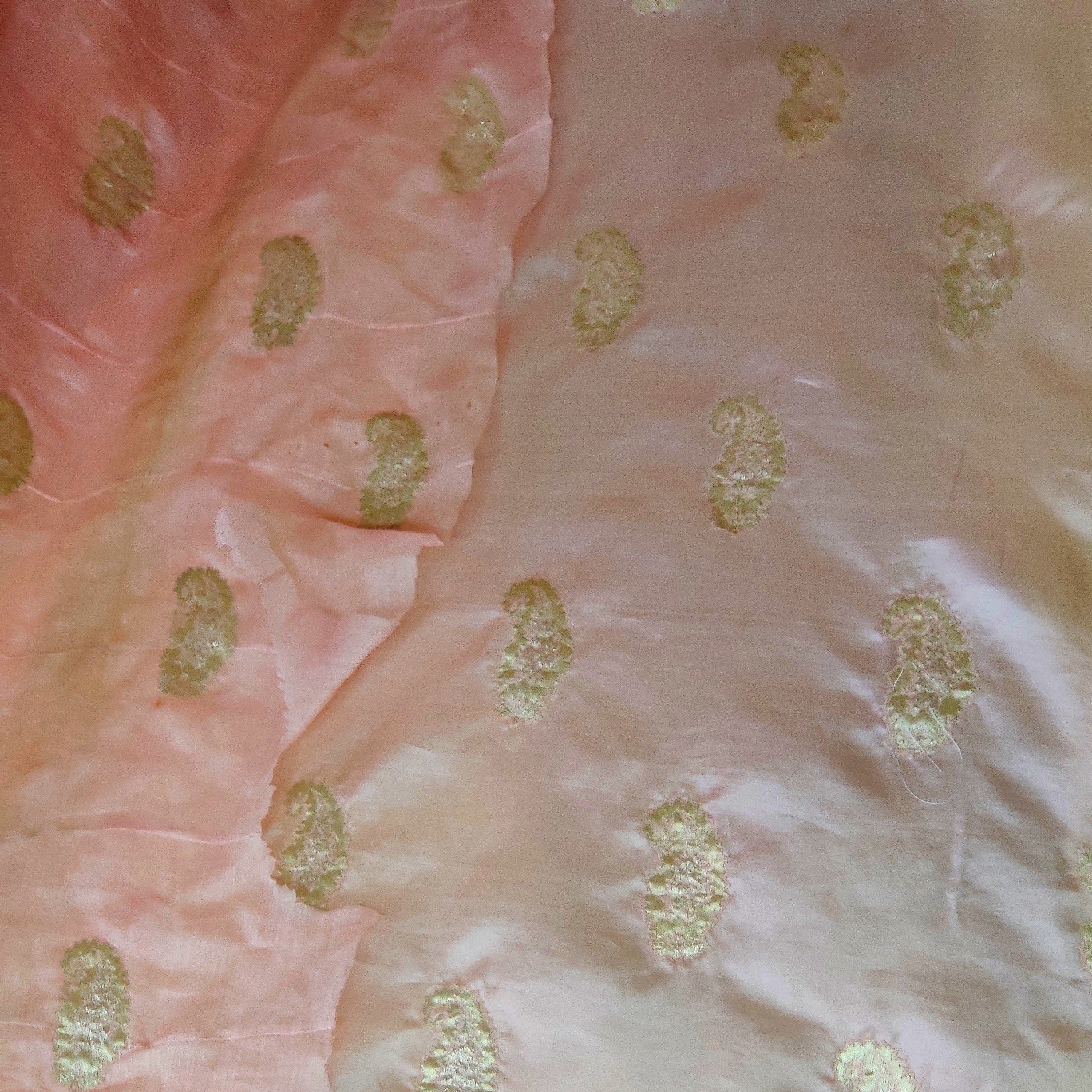Close-up of pink Banarasi saree with gold patterns being transferred for restoration