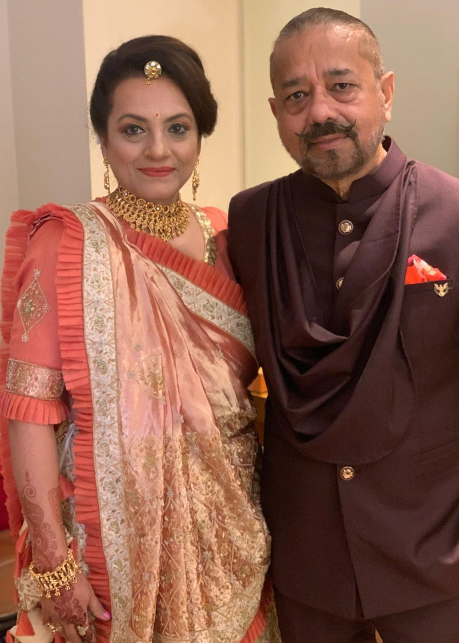 Man and woman in formal attire posing together indoors.